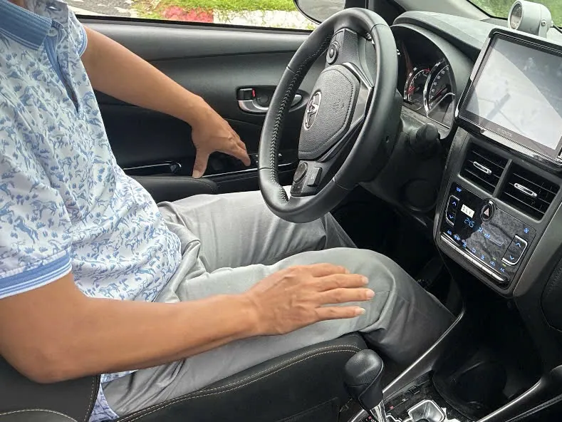 Học viên ngồi ghế lái, tay đặt cạnh vô lăng xe số tự động trong buổi thực hành