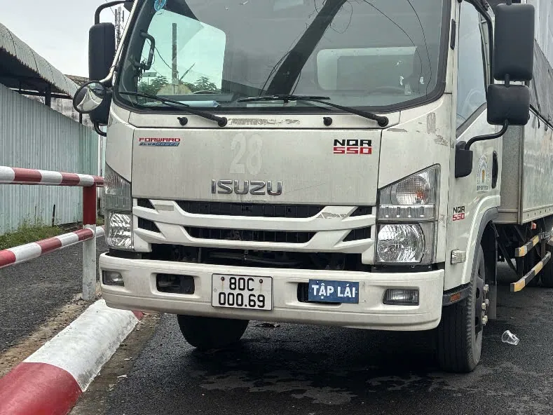 Xe tải thùng màu trắng gắn biển TẬP LÁI đỗ tại sân tập của trung tâm